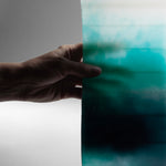 Close-up of AQUA designer candle showing wax layering in soft blue