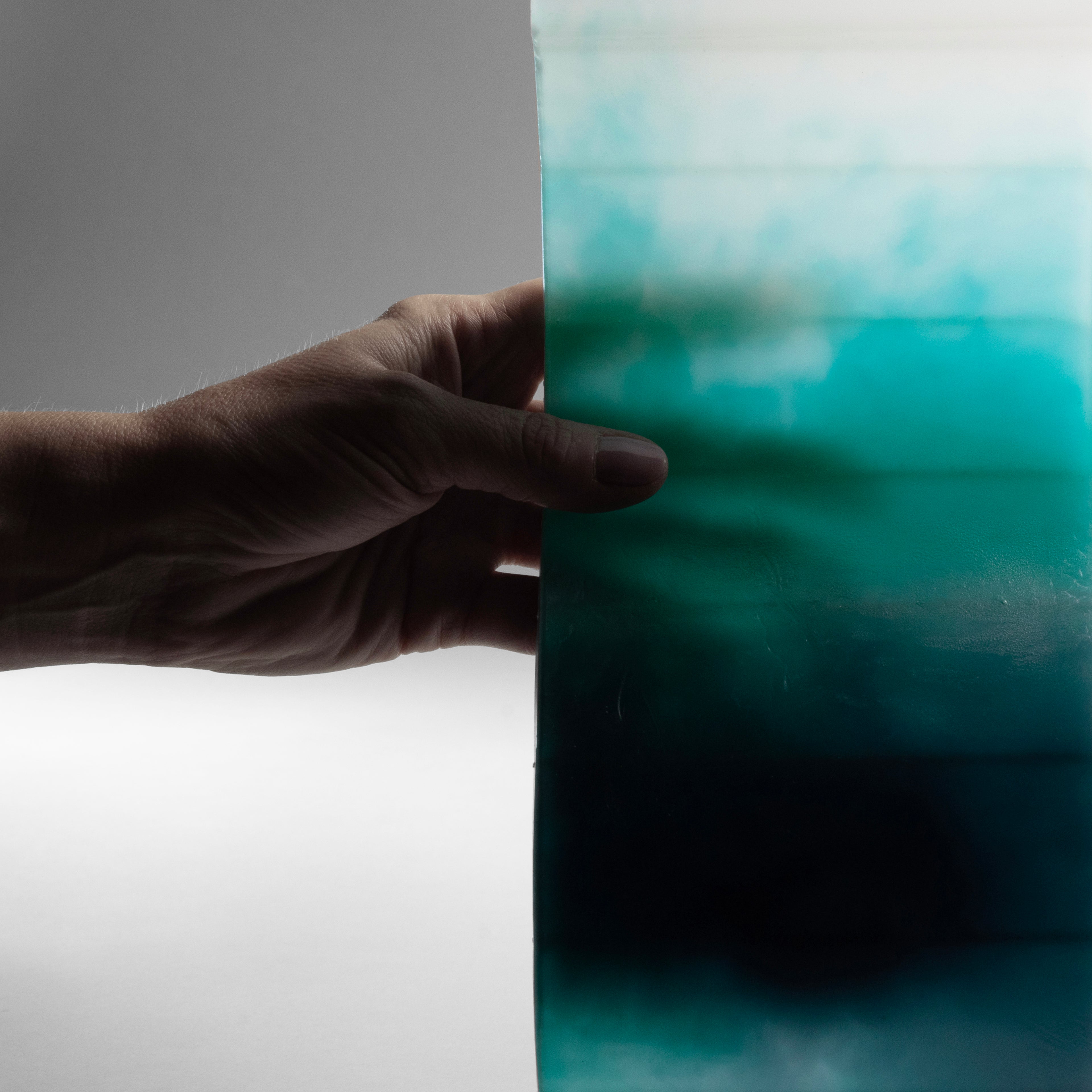 Close-up of AQUA designer candle showing wax layering in soft blue